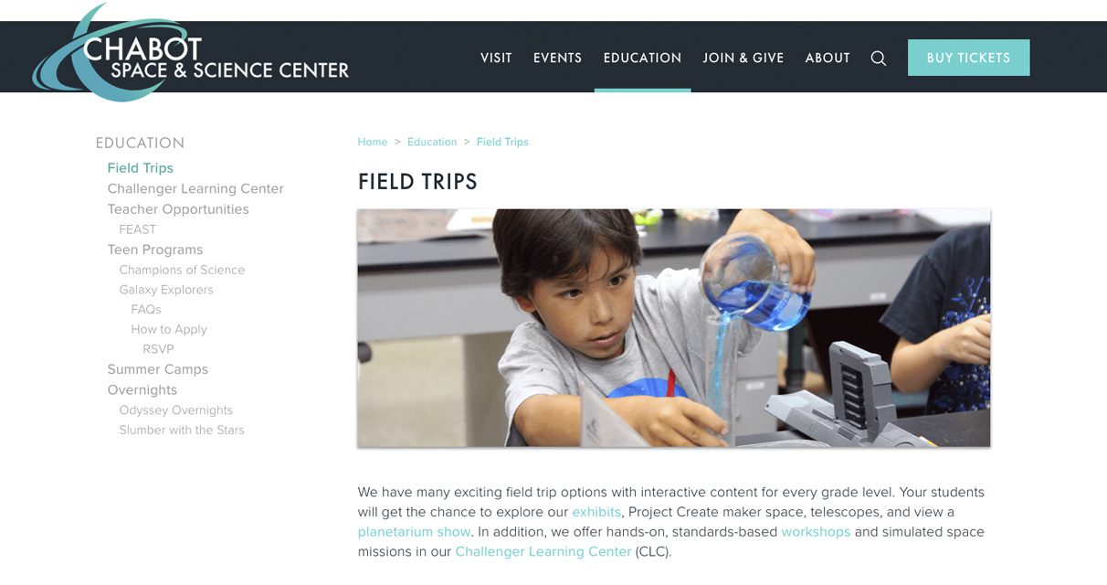 A boy pours blue liquid from a beaker into a graduated cylinder during a science activity at a lab table, on the Chabot Space & Science Center field trips webpage.