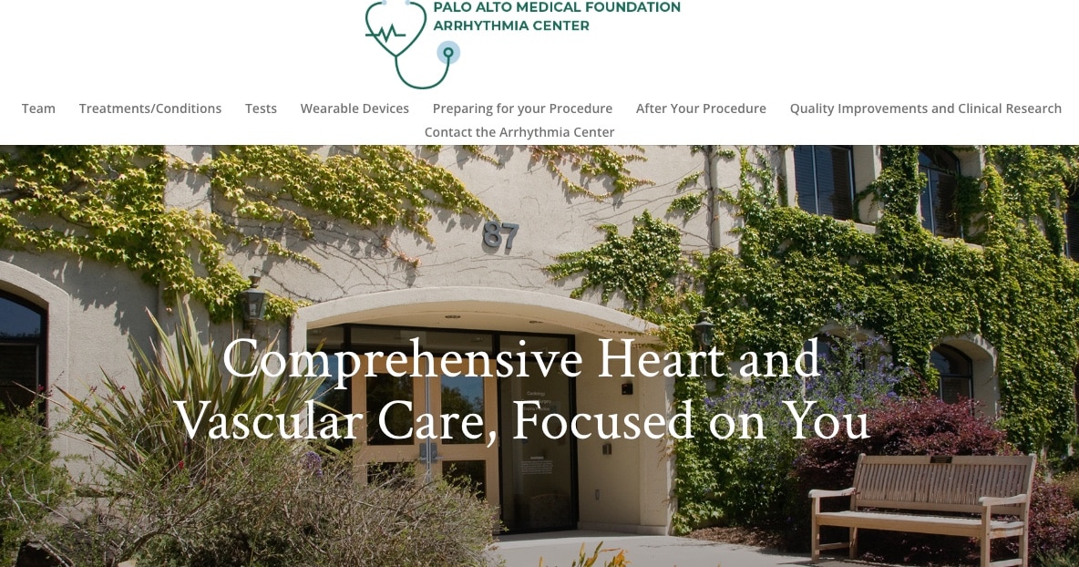 The entrance of Palo Alto Medical Foundation Arrhythmia Center, with greenery and a sign reading Comprehensive Heart and Vascular Care, Focused on You.